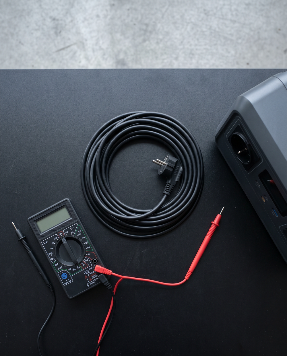 Schuko-Verlängerungskabel, Multimeter und Werkbankzubehör neben dem Stromspeicher DHS-06